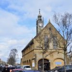 A yellow-stone building with a clock tower.
