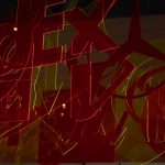 Red, orange and yellow translucent plastic logos, all overlaid in the image (in real life, suspended in front of each other from the ceiling).