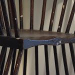 An unusual chair, which would appear the same if turned upside down. The chair is made of dark wood, with a shaped seat portion, and then struts fanning outwards along the sides and back of the seat to form the legs (below) and the back (above).