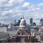 A skyline view of London, with St Paul’s Cathedral in the centre. There are various skyscrapers in the background. The sky is filled with white fluffy clouds, having only patches of blue.